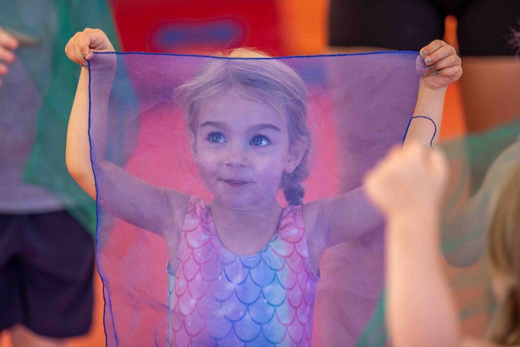young dancer standing behind a veil