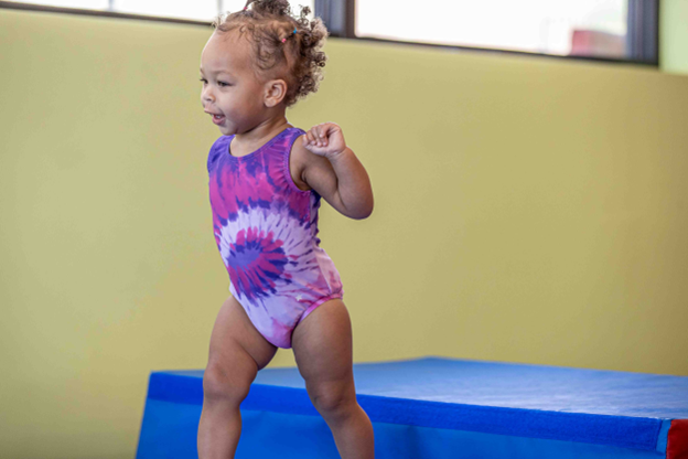 toddler girl in a purple leotard